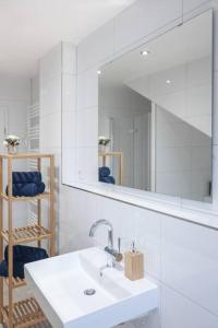 a bathroom with a white sink and a mirror at Top ausgestattet Netflix Wifi Veltins Arena in Gladbeck