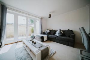 sala de estar con sofá y mesa en Linen Cottage- Parking, LEDs, 4K TVs, 5G WIFI and more!, en Bath