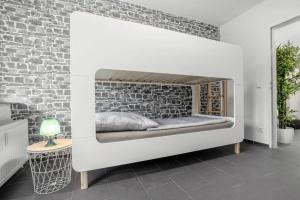 a bed in a room with a brick wall at Top Equipped Netflix WLAN Landschaftspark in Duisburg