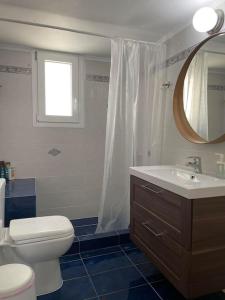 uma casa de banho com um WC, um lavatório e um espelho. em Enchanting Mycenae - Your Greek holiday retreat em Árgos