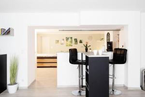 una cocina con encimera negra y taburetes negros en Top Ausstattung Netflix Wlan Messe Altstadt, en Düsseldorf 8 fotos más