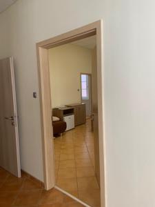 a hallway with a door open to a living room at BF Hotel in Balatonföldvár