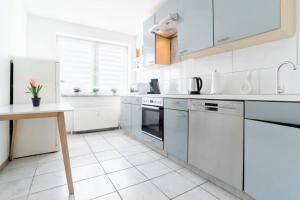 a white kitchen with white appliances and white tile floors at Top Ausstattung Netflix WLAN Landschaftspark in Duisburg