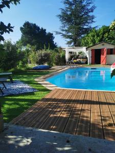 - une piscine avec une terrasse en bois à côté d'une cour dans l'établissement Dépendance cosy entre jardin, piscine et jacuzzi, à Aubagne