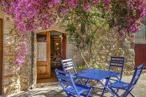 Casa Blava في Orriols: طاولة وكراسي زرقاء أمام مبنى به زهور
