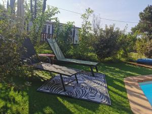 ławka siedząca w trawie obok basenu w obiekcie Dépendance cosy entre jardin et jacuzzi privés et piscine partagée w mieście Aubagne
