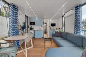 ein Wohnzimmer mit einem Sofa und einem Tisch in der Unterkunft Domy Na Wodzie - La Mare Motlava Houseboats with Sauna by Downtown Apartments in Danzig