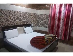 1 dormitorio con cama blanca y cortinas rojas en Sharma Guest House, Naina Devi, Himachal Pradesh en Anandpur Sāhib