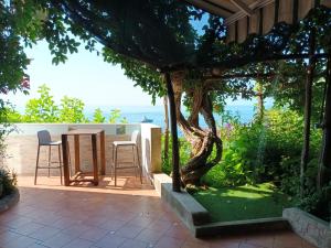 a patio with a table and chairs and a tree at Casa Emi in Amalfi