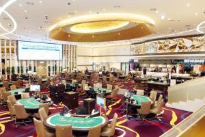 a casino with tables and chairs in a casino at Towerhill Hotel in Busan