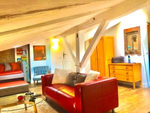 a living room with a red leather couch and a table at Rouge in Tocane-Saint-Apre