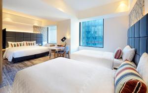 una camera d'albergo con due letti e una finestra di HOTEL CHAM CHAM - Taipei a Taipei Altre 36 foto