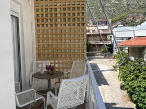 a balcony with a table and chairs and a building at Loutraki apARTment in Loutraki