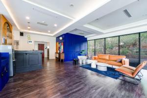 sala de estar de planta abierta con armarios azules y sofá naranja en H& 日月潭水漾 l 伊達邵老街 l 湖景, en Yuchi