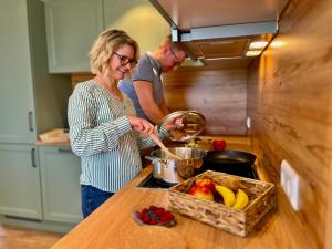 a man and a woman preparing food in a kitchen at Ferienwohnungen mama ELVA in Leutkirch im Allgäu +30 photos