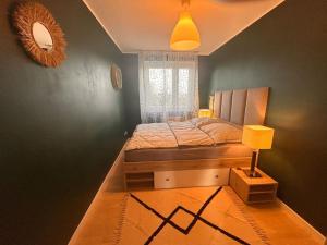 a small bedroom with a bed and a window at Przestronny apartament in Gdańsk