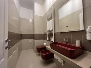 a bathroom with a red sink and two toilets at Palazzo Zippitelli Apartments in Bari