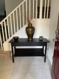 a vase sitting on a table next to a staircase at Beautiful Brand New 2 Bedroom Vegas Home! Fits 12 or more,15-20 minutes from LV Strip in Las Vegas