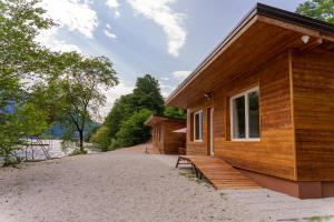 una casa de madera con un banco en el costado en Chalet Alessandrini - Private Lakeside Beach, en Tenna 