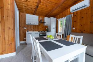 cocina con mesa blanca y sillas en Chalet Alessandrini - Private Lakeside Beach, en Tenna 