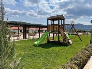 a playground with a slide in the grass at Enigma Complex in Pavel Banya