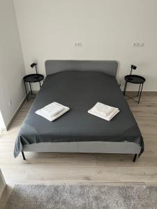 a bed with two white towels on top of it at Bez7 Apartman in Budapest