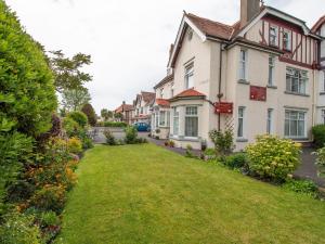 a house with a green lawn in front of it at Rosaire Guest House in Llandudno