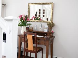 a desk with a mirror and a chair at Rosaire Guest House in Llandudno