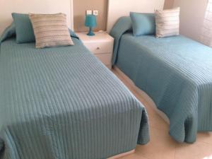 two beds sitting next to each other in a bedroom at APPARTEMENT TOUT CONFORT CLIMATISE in Oued Laou