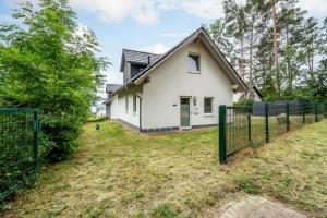 a white house with a fence in front of it at Ferienhaus Alpaka in Plau am See