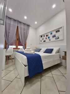 een witte slaapkamer met een blauw en wit bed en een tafel bij Villa Vittoria in Mesagne