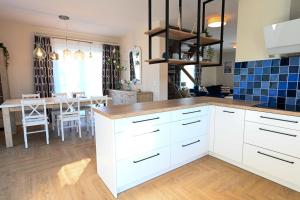 a kitchen with white cabinets and a dining room at Ferienhaus Anni in Puddemin