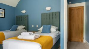 Dos camas en una habitación con paredes azules. en Home Farmhouse, en Rusland 23 fotos más
