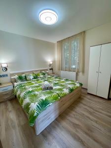 um quarto com uma cama grande e um cobertor verde em Lisza Apartman Siófok em Siófok