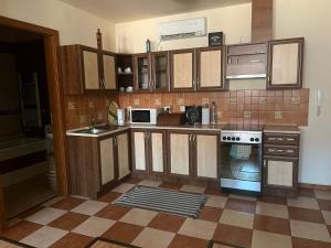 a kitchen with wooden cabinets and a stove at Árnyas Residence Apartman Pécs in Pécs