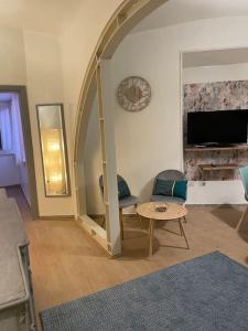 a living room with an archway with a table and chairs at Blue vatican house Rome in Rome
