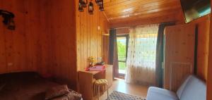 a room with a wooden wall with a large window at pensiunea top demac in Slănic