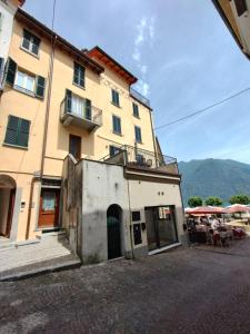 a large yellow building with a balcony and a table at Al Pontile - by My Home In Como in Argegno