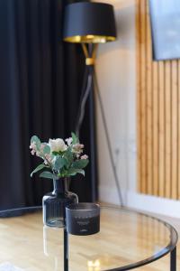 a black vase with flowers on a glass table at Premium Apartment - Allocated Parking - Great Location in Plymouth