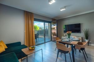 a living room with a couch and a table with chairs at Apartament Widok 1 in Piechowice