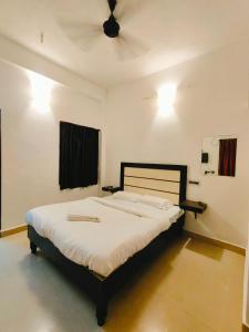 una camera da letto con un letto con lenzuola bianche e un soffitto di La Dreamy Residency a Pondicherry