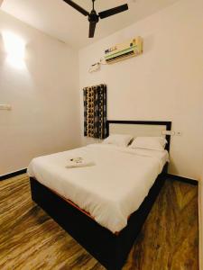una camera da letto con un grande letto con lenzuola bianche di La Dreamy Residency a Pondicherry