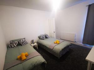 a bedroom with two beds with stuffed animals on them at Sutherland Place - Near Derby City Center in Derby