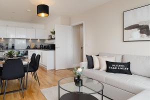 a living room with a white couch and a table at Premium Apartment - Allocated Parking - Great Location in Plymouth