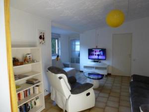 a living room with a couch and a tv at les Oiseaux - Pinède avec piscine in Argelès-sur-Mer