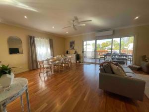 sala de estar con sofá y mesa con sillas en Award winning - Open plan Coastal Beauty in Patonga Beach - Pet Friendly, en Patonga