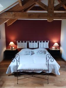 a bedroom with a white bed with a red wall at LA MAISON FORTE in Montaut