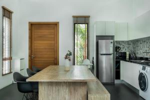 eine Küche mit einem Holztisch und einem Kühlschrank in der Unterkunft Coco Kamala from VillaCarte in Kamala Beach