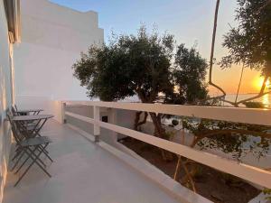 a balcony with a tree and a table and chairs at 31 Seafront Apartment in Kampos Paros