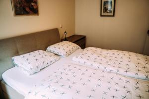 een slaapkamer met een bed met 2 kussens erop bij Huis aan de Haven in Lemmer